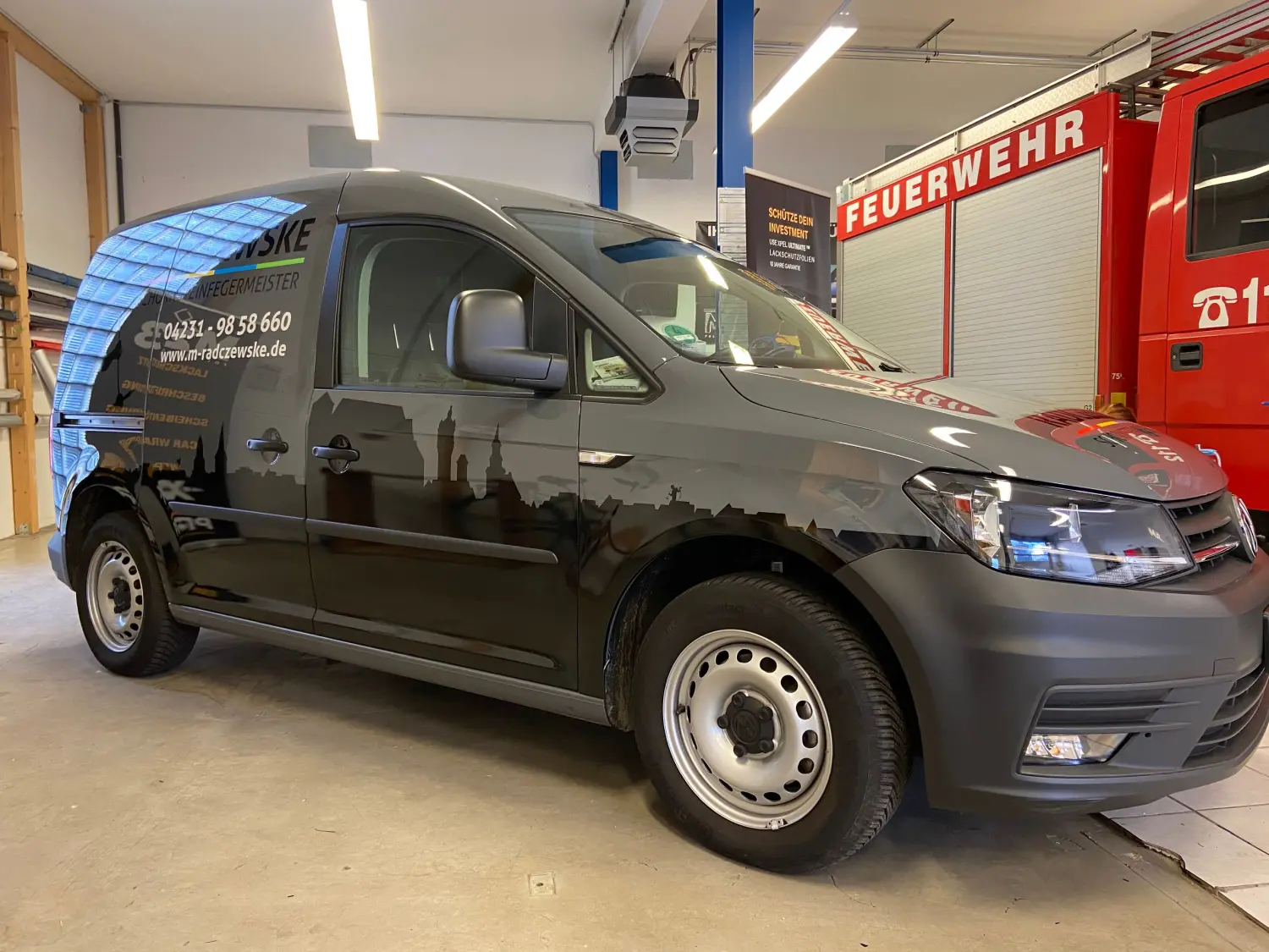 M23 FOILING, ein schwarzes Auto mit Schlossbeschriftung